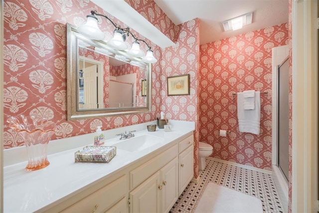 bathroom with vanity, toilet, and a shower with door