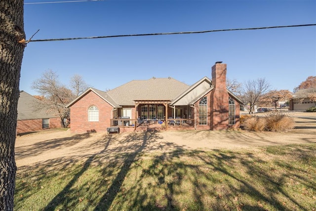 rear view of property with a pergola, a lawn, and a patio