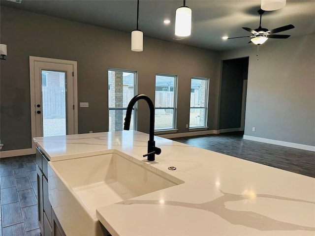 kitchen featuring open floor plan, light countertops, dark wood-type flooring, and a sink