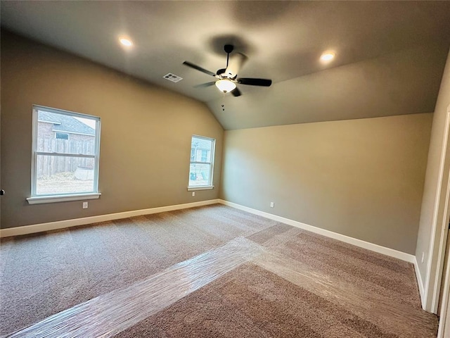 interior space featuring visible vents, a ceiling fan, baseboards, and vaulted ceiling