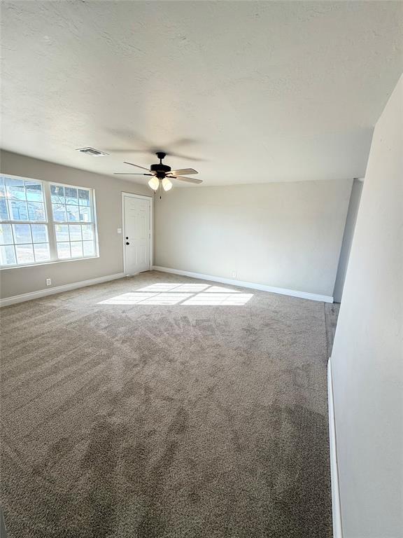 carpeted spare room with ceiling fan