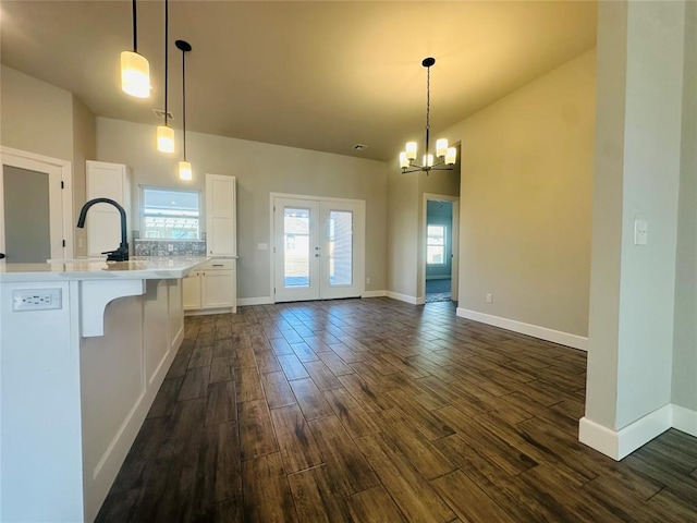 kitchen featuring white cabinets, hanging light fixtures, sink, and a breakfast bar area