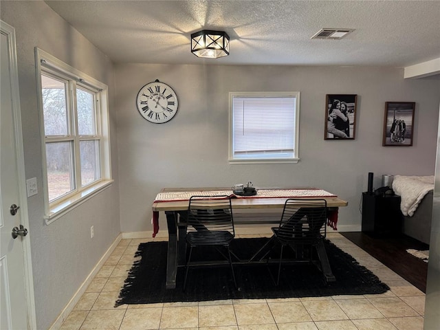 tiled dining area featuring a textured ceiling