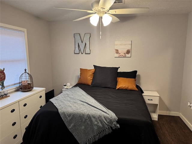 bedroom with dark hardwood / wood-style floors and ceiling fan