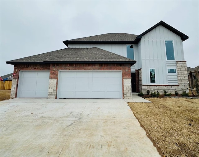 view of front of home featuring concrete driveway, an attached garage, board and batten siding, and roof with shingles