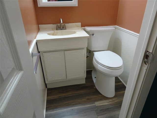 bathroom featuring vanity, wood-type flooring, and toilet