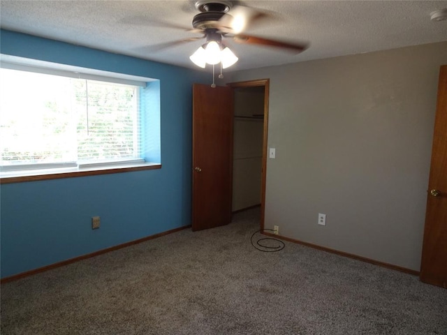 unfurnished bedroom with ceiling fan, carpet floors, and a textured ceiling