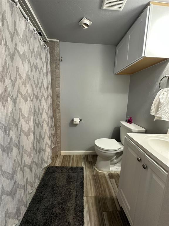 bathroom with hardwood / wood-style floors, vanity, and toilet