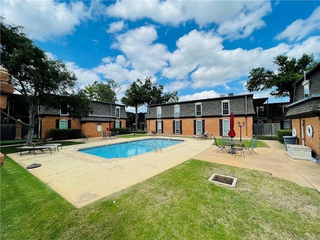 view of pool with a yard and a patio