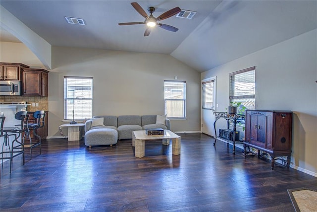 living room featuring vaulted ceiling, ceiling fan, and dark hardwood / wood-style floors