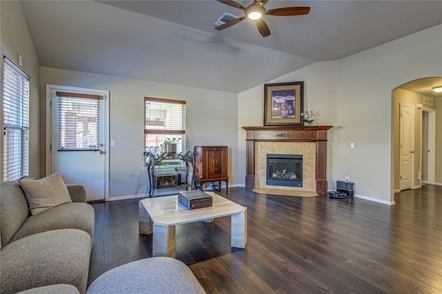 living room with vaulted ceiling, a fireplace, ceiling fan, and dark hardwood / wood-style flooring