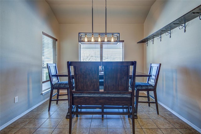 tiled dining area featuring vaulted ceiling