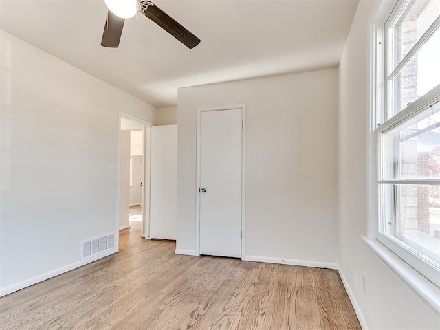 unfurnished bedroom featuring multiple windows, ceiling fan, and light hardwood / wood-style flooring