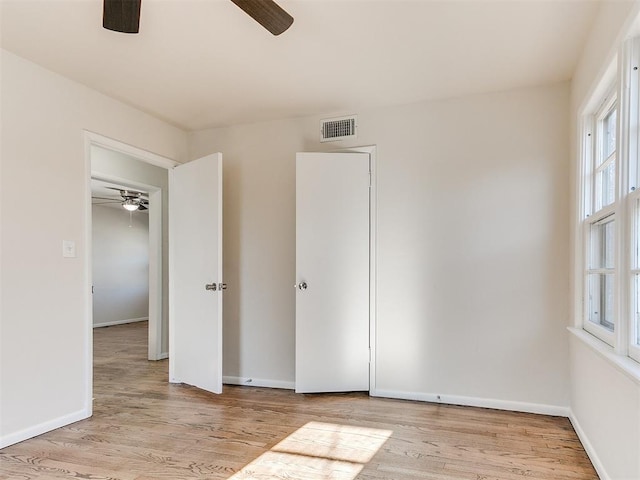 unfurnished bedroom with ceiling fan and light wood-type flooring