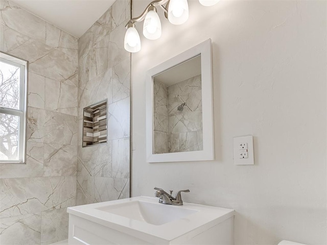 bathroom with vanity and tiled shower