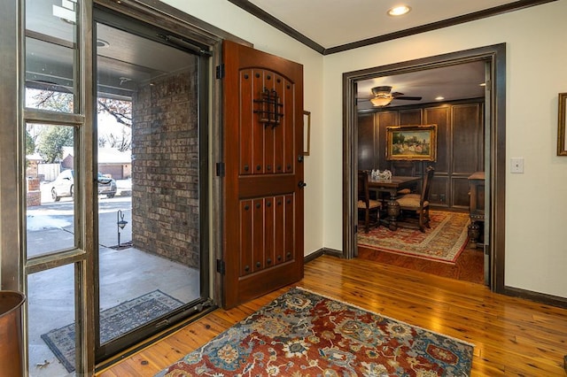 entryway featuring hardwood / wood-style floors, ceiling fan, and crown molding