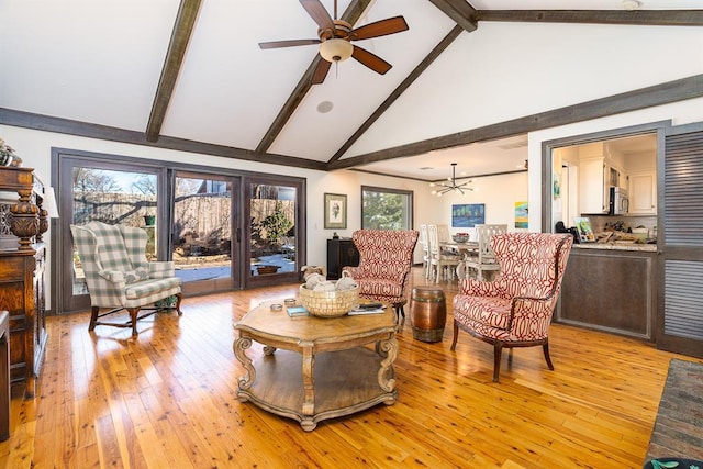 living room with beamed ceiling, ceiling fan with notable chandelier, light hardwood / wood-style floors, and high vaulted ceiling