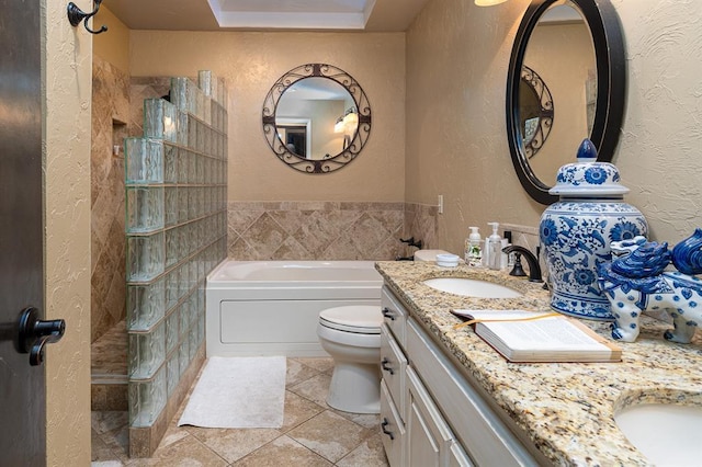 bathroom with tile patterned floors, a tub, vanity, and toilet