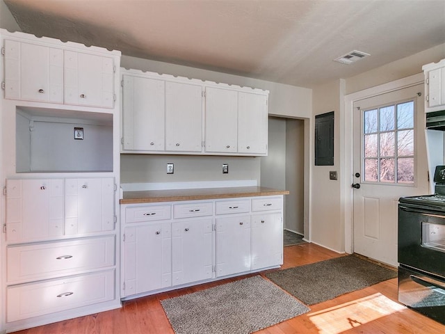 kitchen featuring electric range, white cabinetry, light hardwood / wood-style floors, and electric panel