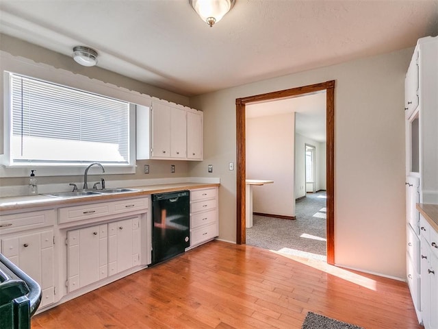 kitchen featuring sink, black dishwasher, white cabinetry, and light hardwood / wood-style floors