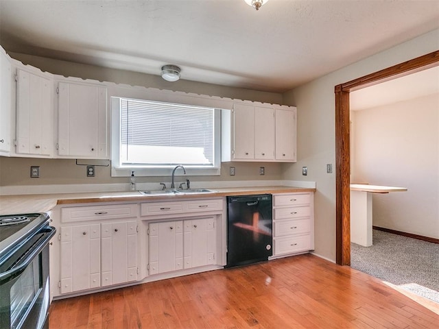 kitchen with light hardwood / wood-style flooring, white cabinets, black appliances, and sink