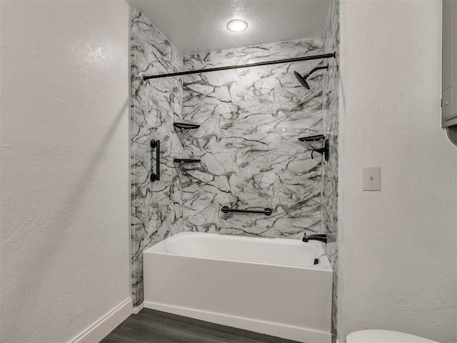 bathroom featuring toilet, a textured ceiling, hardwood / wood-style flooring, and shower / bath combination