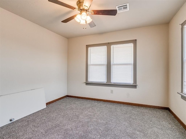 carpeted spare room with a healthy amount of sunlight and ceiling fan