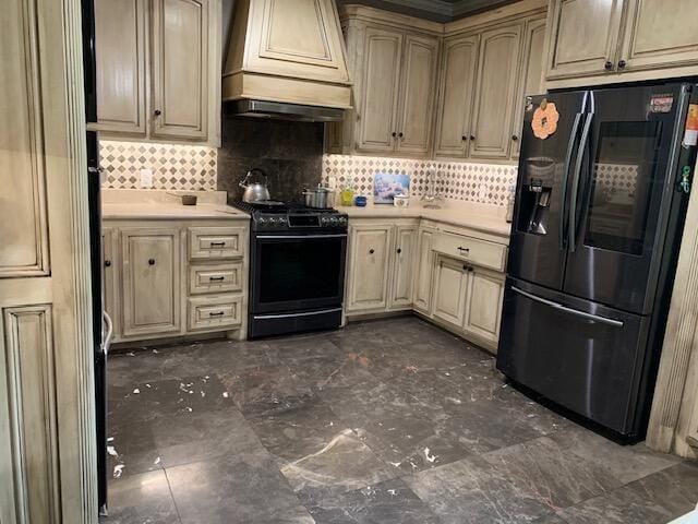 kitchen with black range, custom range hood, decorative backsplash, and refrigerator with ice dispenser