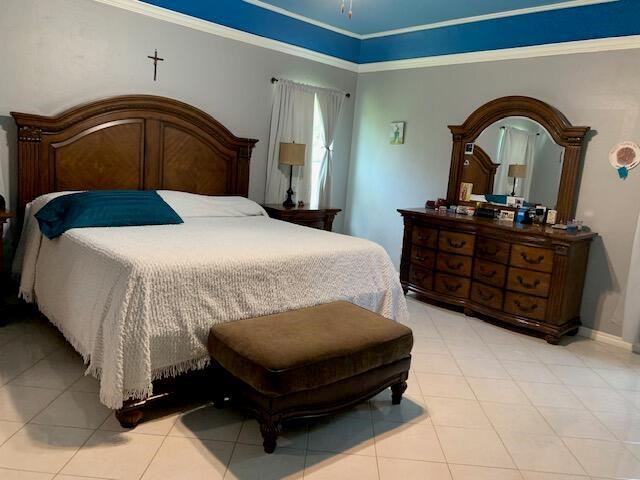 bedroom with crown molding and light tile patterned floors