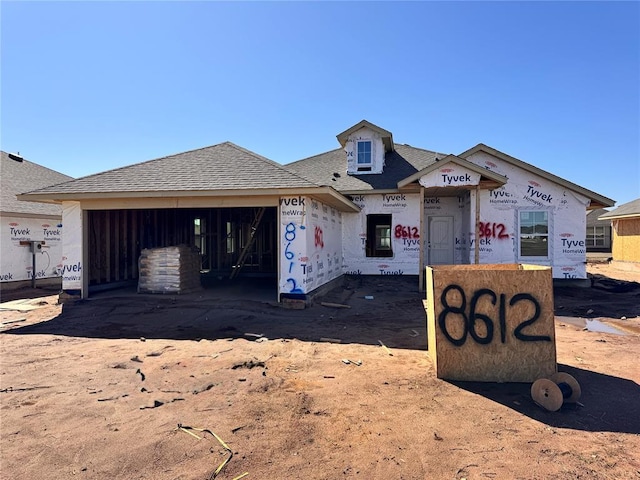 property in mid-construction with a garage and roof with shingles