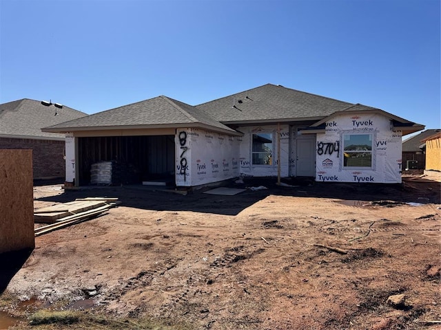 property in mid-construction with a garage and a shingled roof