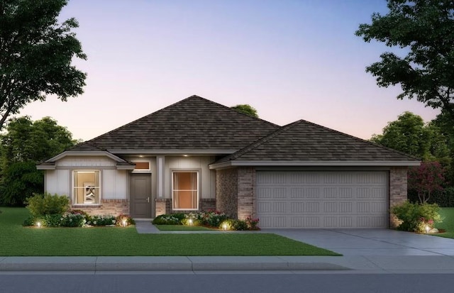 view of front of house with brick siding, driveway, a front yard, and a garage