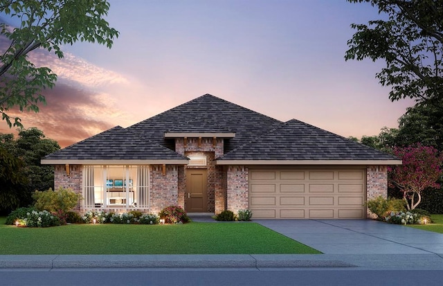 view of front of house with driveway, a yard, an attached garage, a shingled roof, and brick siding