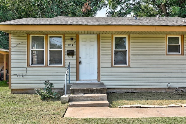 view of exterior entry with a yard