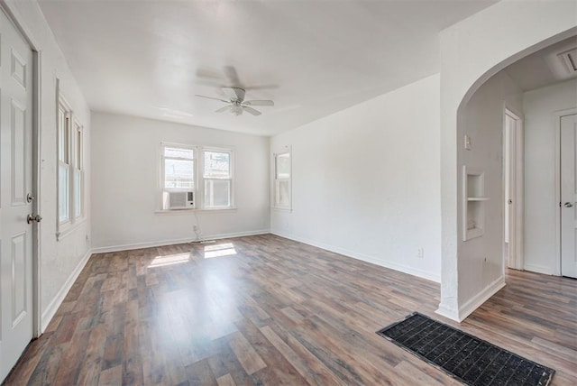 spare room featuring ceiling fan, built in features, and dark hardwood / wood-style flooring