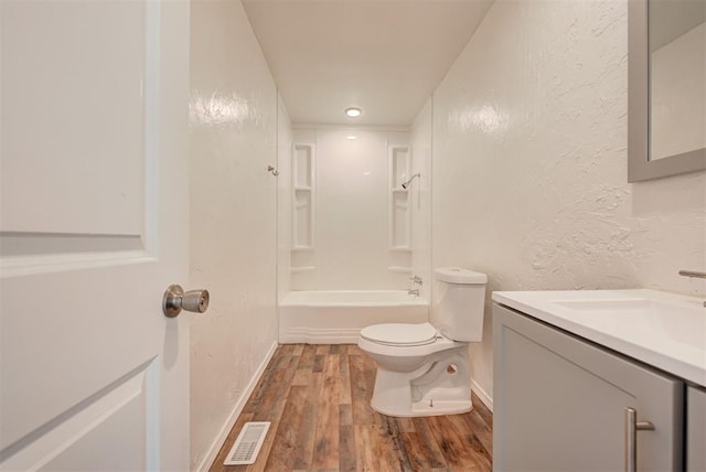 full bathroom with toilet, vanity, wood-type flooring, and tub / shower combination