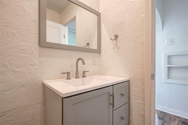 bathroom with hardwood / wood-style floors, vanity, and built in shelves