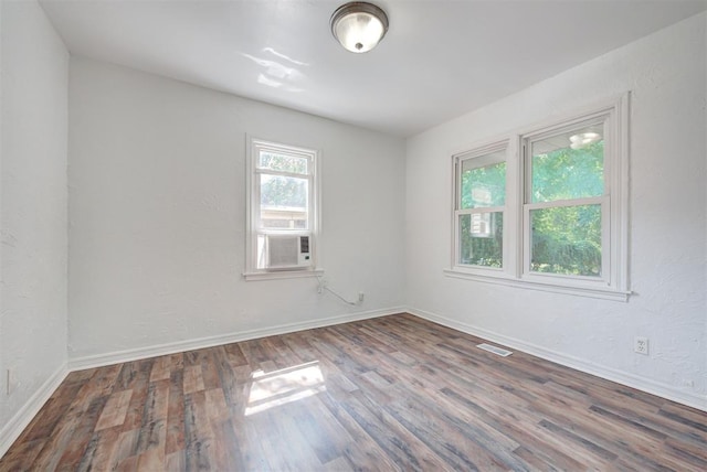 spare room featuring cooling unit and hardwood / wood-style floors