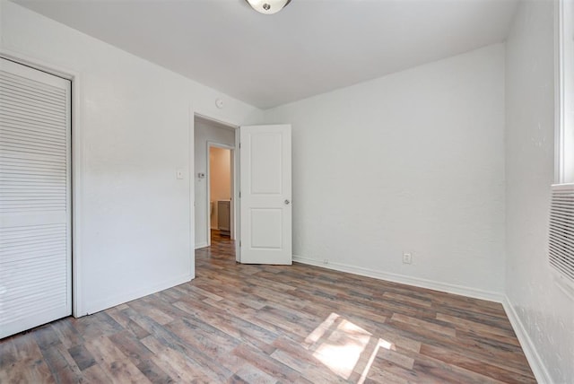 unfurnished bedroom featuring wood-type flooring and a closet