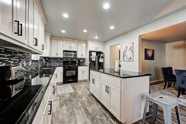 kitchen featuring white cabinetry, sink, black appliances, and a kitchen island