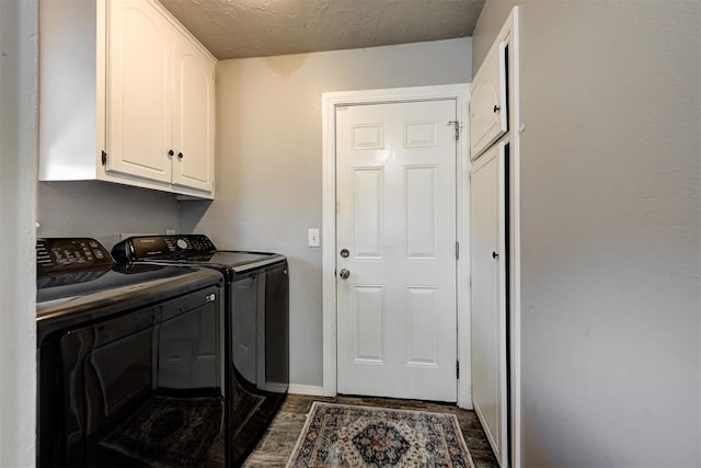 washroom featuring cabinets, dark hardwood / wood-style flooring, a textured ceiling, and washer and clothes dryer