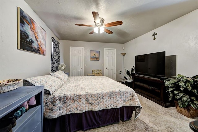 carpeted bedroom with ceiling fan and a textured ceiling