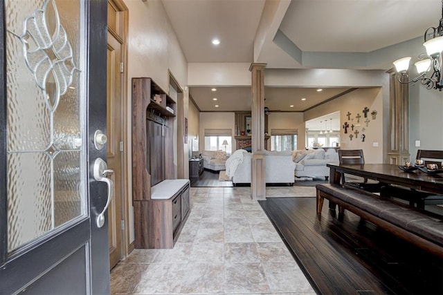 foyer featuring ornate columns and a notable chandelier