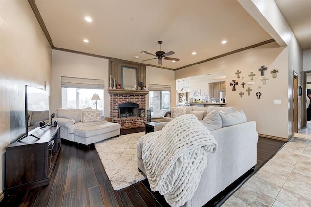 living area with recessed lighting, ornamental molding, ceiling fan, and a fireplace