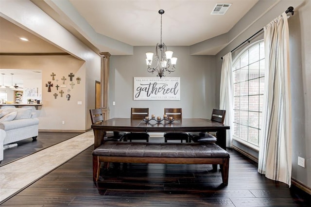 dining room with dark wood-style flooring, a notable chandelier, visible vents, and plenty of natural light