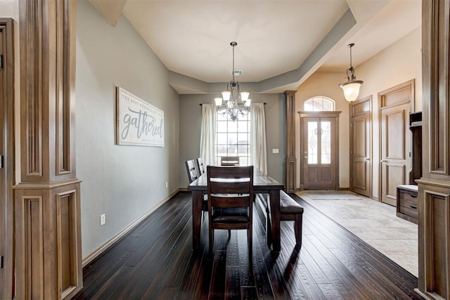 dining room with baseboards, dark wood finished floors, and a chandelier
