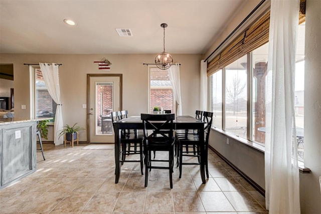 dining room with a chandelier, baseboards, visible vents, and light tile patterned floors