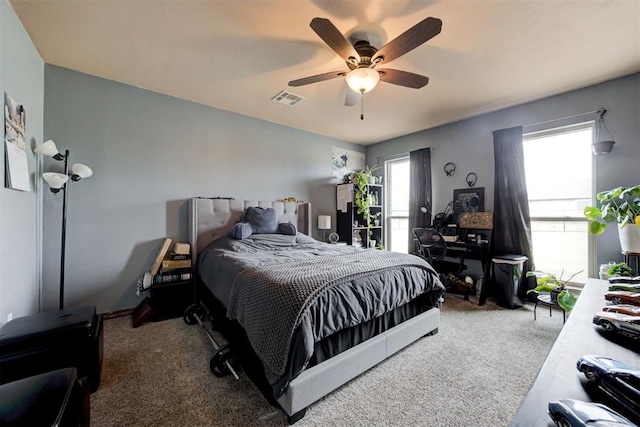 carpeted bedroom featuring ceiling fan and visible vents