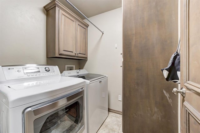 clothes washing area with light tile patterned floors, cabinet space, and independent washer and dryer