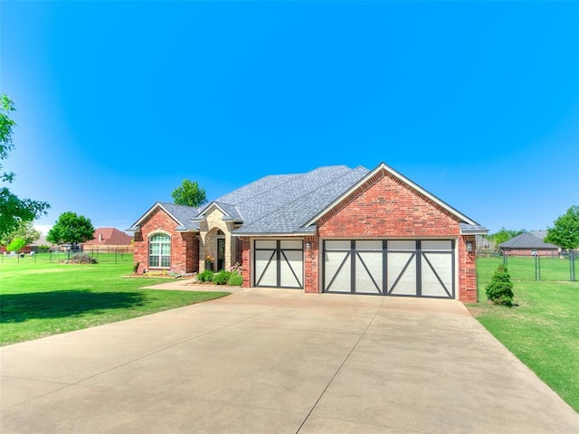 view of front facade with fence, driveway, and a front lawn